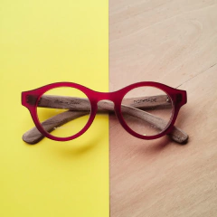 anteojos de madera (patillas) y acetato (frente) color rojo traslucido con forma redonda para colocar lentes de aumento modelo Santorini marca Nomade vista medio perfil