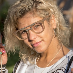 mujer con anteojos de madera (patillas), acetato (aros del frente) color oro y acero (puente y barral) modelo Ankara marca Nómade
