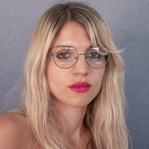 mujer joven con pelo rubio largo usando anteojos redondos de metal color verde oscuro modelo Lanin marca Nomade