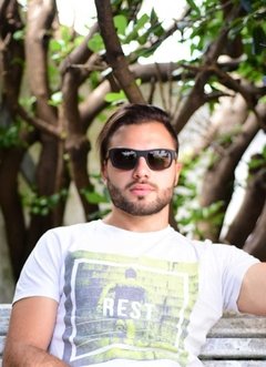 Hombre luciendo anteojos de madera (patillas) y acetato (frente) color negro rectangular con lentes de sol polarizados modelo Córcega marca Nómade 