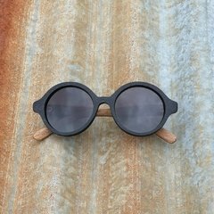 anteojos de sol de madera (patillas) y acetato negro (frente) con lentes polarizados modelo Viena marca Nómade. vista de frente