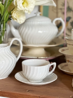 Taza de té con plato de loza inglesa blanca