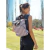 Mochila plegable Aqua con diseño a rayas, llevada por una mujer en un parque.