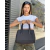 Mujer sosteniendo una cartera de mano Cocó simil neoprene en un ambiente urbano.