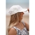 Gorra de verano blanca en la cabeza de una mujer con cabello largo, sonriendo en la playa.