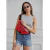 Modelo luciendo una riñonera roja Venecia - Bomber, con camiseta sin mangas y pantalones cortos de jean.