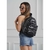 Mochila Luna - Bomber negra, modelo de moda, con detalles de cremalleras, llevada por una mujer que viste un top gris y shorts de mezclilla.