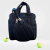 Bolso de padel negro con raqueta y pelotas de tenis en una cancha.