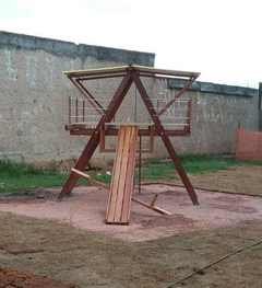 Playground de madeira grande com escorregador e estrutura de balanço.