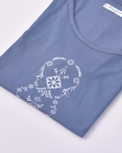 Remera Elizabeth de color azul con diseño floral en blanco, presentada de manera ordenada.