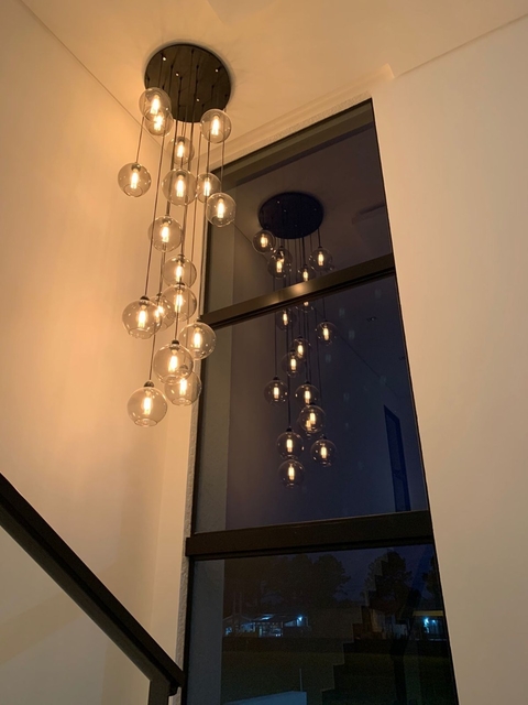 Lustre Pendente Sarvah com 18 globos, base redonda preta, instalado em ambiente com pé direito duplo. Lustres Gênesis loja online de Lustres e Iluminação Decorativa