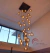Lustre pendente Sarvah com 36 globos transparentes iluminados em um ambiente de pé direito duplo. Lustres Gênesis loja online de Lustres e Iluminação Decorativa. 