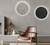 Arandela Moderna Stone Concreto iluminando uma sala de estar moderna com poltrona de couro marrom. Lustres Gênesis Site online venda de Lustres e Iluminação
