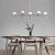 Lustre pendente moderno Sears dourado em sala de jantar com mesa e cadeiras de madeira. Lustres Gêneis loja online de Lustres e Iluminação Decorativa