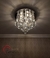 Lustre Plafon de Cristal em formato pirâmide redondo instalado no teto, iluminando a sala de forma elegante. Lustres Gênesis loja online de Lustres e Iluminação Decorativa