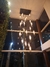 Lustre Pendente Moderno Dunáh com 21 tubos de vidro fumê em um ambiente com pé direito alto. Lustres Gênesis loja online de Lustres e Iluminação Decorativa
