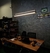 Lustre Pendente de LED Moderno Fit Linear Slim Triplo iluminando escritório com mesa de madeira e parede cinza.