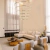 Lustre pendente moderno de LED com seis anéis dourados em uma sala de estar elegante. Lustres Gênesis loja online de Lustres e Iluminação Decorativa