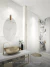 Espelho Moderno Slim Oval com Alça de Couro em banheiro elegante com pia dourada e decoração sofisticada.