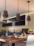 Luminária Pendente Cata Vento em madeira sobre mesa de jantar em cozinha moderna. Lustres Gênesis loja online venda de Lustres e Iluminação