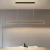 Lustre pendente de LED moderno em dourado, instalado sobre uma mesa de jantar em ambiente minimalista. Lustres Gênesis Site online venda de Lustres e Iluminação Decorativa