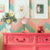 Luminária de mesa abajur Pixar rosa sobre uma cômoda decorada com ursinho de pelúcia e vaso de flores. Lustres Gênesis Site online venda de Lustres e Iluminação