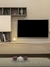 Luminária Vela Contemporânea ao lado de uma televisão em uma sala de estar moderna. Lustres Gênesis Site online venda de Lustres e Iluminação