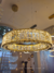 Lustre pendente com cristal decorado e LED Luna dourado em exibição em uma loja. Lustres Gênesis loja online venda de Lustres e Iluminação