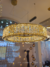 Lustre pendente com cristal decorado e LED Luna Dourado em uma sala de exposição. Lustres Gênesis loja online venda de Lustres e Iluminação