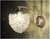 Arandela Dente de Leão de cristal iluminada, com medidas de 20x15cm, ideal para cabeceira de cama, lavabo e banheiro. Lustres Gênesis loja online de Lustres e Iluminação Decorativa