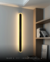 Arandela Moderna Fit Linear Slim Preto 80cm com luz direta de LED instalada em uma parede ao lado de uma estante. DCB03155  Lustres Gênesis - o melhore site da Internet para comprar Lustre