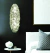 Arandela Dente de Leão 30x20cm Cristal instalada ao lado de uma cabeceira de cama. Lustres Gênesis loja online de Lustres e Iluminação Decorativa