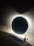 Espelho moderno redondo com LED aceso, destacando luz indireta em ambiente escuro. Lustres Genesis loja online de Lustres e Iluminação Decorativa