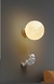 Arandela moderna em formato de astronauta escalando, com acabamento dourado, ideal para quarto, cabeceira de cama ou lavabo. Lustres Genesis loja online de Lustres e Iluminação Decorativa