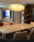 Lustre pendente de cristal Zeppelin com base dourada iluminando sala de jantar moderna. Lustres Gênesis loja online de Lustres e Iluminação Decorativa