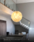 Lustre pendente de cristal em formato de esfera iluminando uma sala de jantar com pé direito duplo. Lustres Gênesis loja online de Lustres e Iluminação Decorativa