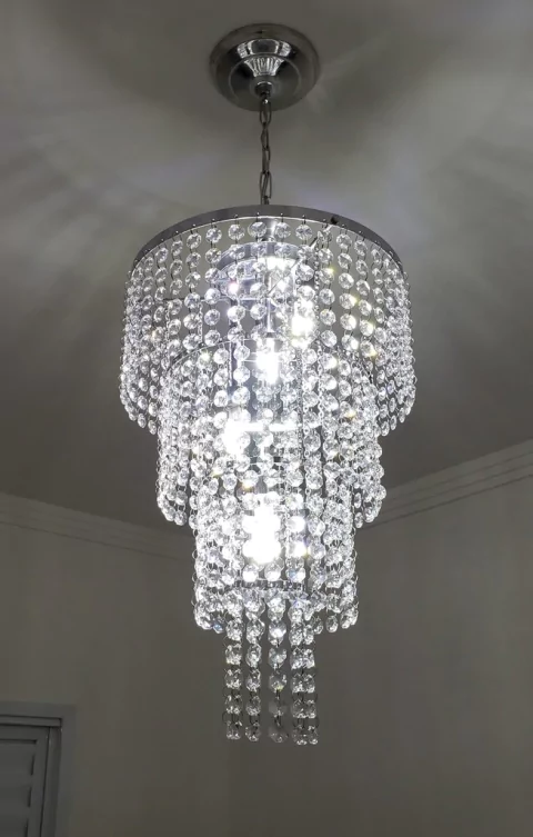 Lustre pendente de cristal Doma Ø50cm iluminado em uma sala. Lustres Gênesis loja online de Lustres e Iluminação Decorativa
