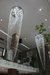 Dois lustres de cristal pendentes em um ambiente interno moderno com mezanino e plantas. comprar lustres, luminarias e pendentes na Lustres Gênesis