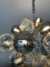 Luminária de teto pendente dourada com globos Fumê Niblos, destacando detalhes em cristal e design moderno.