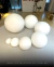 Globos de vidro fosco leitoso de diferentes tamanhos em uma exposição. Lustres Gênesis loja online de Lustres e Iluminação Decorativa