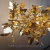 Lustre folhado a ouro com design de pétalas, ideal para sala de jantar e ambientes sofisticados. Lustres Gênesis Site online venda de Lustres e Iluminação
