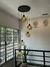 Lustre pendente Sarvah com 5 globos em um ambiente interno com pé direito alto. Lustres Gênesis loja online de Lustres e Iluminação Decorativa