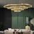 Lustre pendente moderno com três anéis dourados em uma sala de estar elegante. Lustres Gênesis Site online venda de Lustres e Iluminação