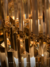 Detalhe do lustre de cristal Lux Dourado com design sofisticado e acabamento em ouro. Lustres Gênesis loja online de Lustres e Iluminação Decorativa. 