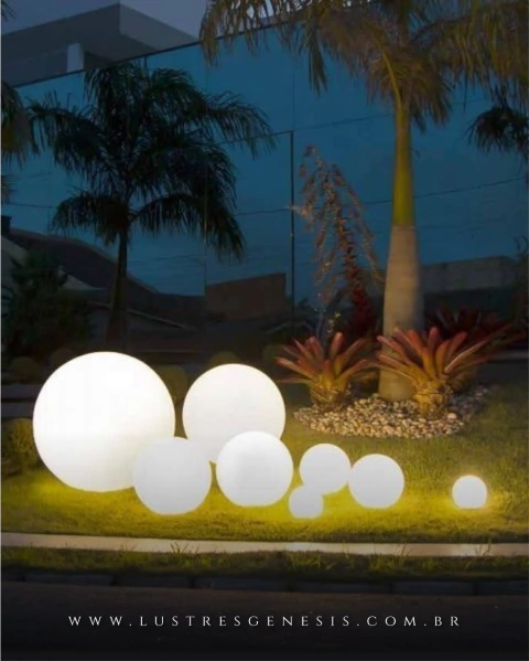 Luminária de Chão Esfera Soleil Branca iluminando jardim externo à noite. Lustres Gênesis loja online de Lustres e Iluminação Decorativa