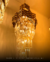 Lustre pendente de cristal Square para pé direito duplo e alto, modelo Sindora, exibido em ambiente interno iluminado Lustres Grande da Gênesis Site online venda de Lustres e Iluminação Decorativa