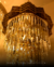 Lustre pendente de cristal Square para pé direito duplo da marca Sindora, iluminado em ambiente interno. Lustres Grande da Gênesis Site online venda de Lustres e Iluminação Decorativa
