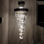 Lustre pendente de cristal Líbia preto de 260cm iluminando um ambiente interno sofisticado. Lustres Gênesis Site online venda de Lustres e Iluminação Decorativa