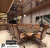 Sala de jantar moderna com luminárias pendentes douradas e mesa de madeira cercada por cadeiras estofadas. Lustres Gêneiss loja online de Lustres e Iluminação Decorativa