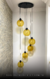 Lustre pendente Sarvah moderno com 6 globos âmbar, ideal para escadas e casas com pé direito duplo e alto. Lustres Gênesis loja online de Lustres e Iluminação Decorativa